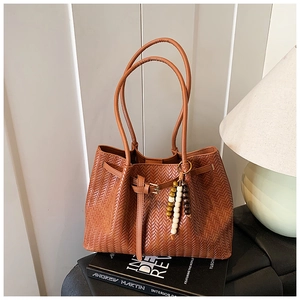 Détail du sac cabas vintage tissé avec perles en bois et boucle dorée décorative