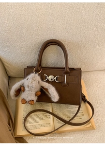 Retro brown bag with heart buckle and rabbit plush charm on vintage open book
