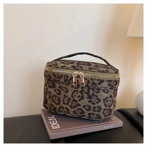 Détail de la trousse de maquillage léopard avec large poignée et double zip doré