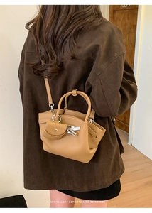 Detail of light brown lychee grain leather tote bag with a retro minimalist shoulder strap