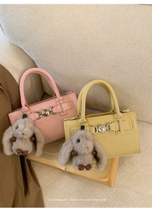 Detail of lychee pattern crossbody bag with heart buckle and rabbit plush pendant