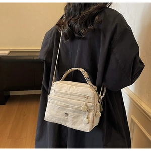 Detail of off-white multi-layer nylon crossbody bag with large storage space and wide strap