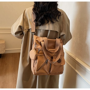 Brown nylon tote bag shown on a model featuring multiple pockets and a small round pouch