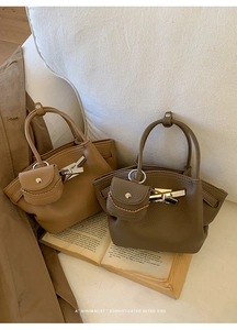 Detail of khaki and brown pleated bucket bags with mini pouches and metal buckles