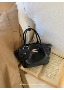 Detail of black lychee grain leather underarm bag with silver buckle and mini coin purse