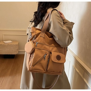 Caramel canvas tote bag detail featuring multiple zip pockets and detachable round coin purse