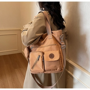 Detail of caramel tote bag showing detachable wide strap and side round coin purse