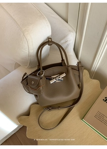 Detail of brown litchi pattern leather bag with silver buckle and mini pouch accessory