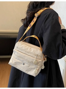 Minimalist beige nylon crossbody bag with multi-zipper pockets and yellow floral strap