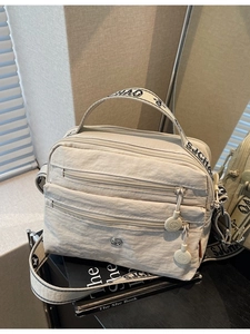Beige multi-pocket nylon crossbody bag with adjustable letter strap and zipper detail