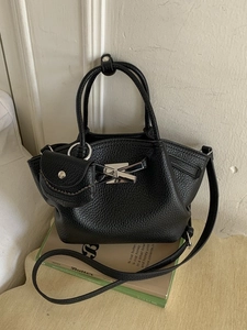 Minimalist black lychee pattern bucket bag with silver bow hardware and small pouch
