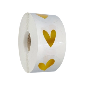 Roll of gold foil heart stickers on transparent round labels for gift packaging