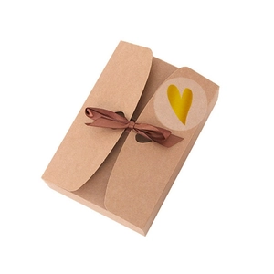 Brown kraft gift box with dark brown ribbon bow and gold heart transparent seal sticker