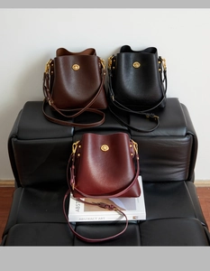 Detailed trio of leather bucket bags in brown, black and burgundy with gold C-buckle