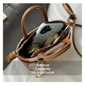 Internal view of a small brown handbag showing capacity for phone and cosmetics