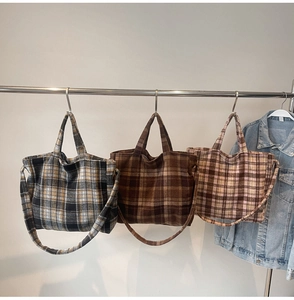 Gros plan détaillé de sacs cabas en laine à carreaux colorés avec poignées et bandoulières