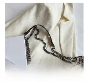 Close-up of silver metal chain strap and colorful woven texture on the tote bag