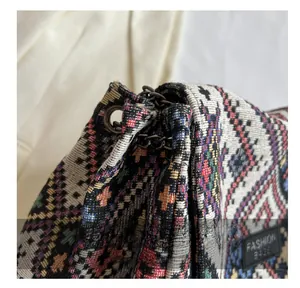 Detail of vintage ethnic tote bag showing metal eyelets and chain strap link