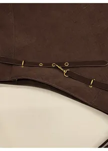 Detailed macro view of deep brown leather woven texture with gold buckle and hardware