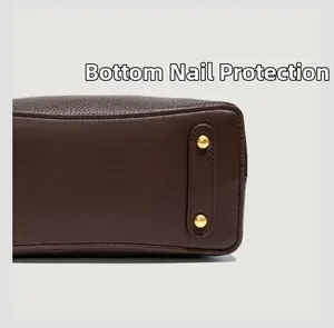 Detail of golden bottom studs protection on high-quality brown litchi grain leather bag