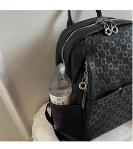 Close-up of side pocket on black leather backpack holding a water bottle with metal zip