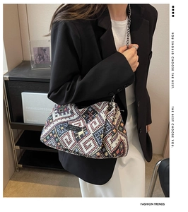 Detail of colorful woven bohemian shoulder bag with silver chain strap on model