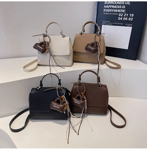 Litchi texture leather handbags in four colors displayed on geometric stands with mini charms