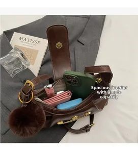 Detail view of brown dumpling bag interior showing capacity with phone and wallet