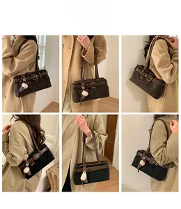 Detailed views of dark suede baguette bag with vintage leather trim and plush charm