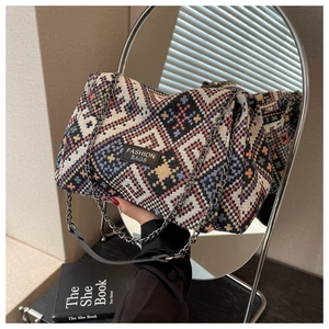 Detail of colorful jacquard fabric tote bag with chain strap and geometric pattern