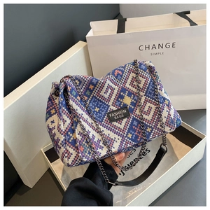Detail of bohemian tote bag with blue geometric pattern and metal chain strap