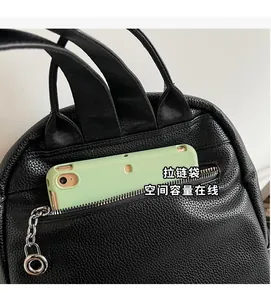 Detail showing the back zipper pocket of this black pebbled leather backpack with a smartphone