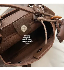 Detailed close-up of strong magnetic buckle and interior texture of the brown leather bag