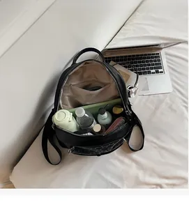 Internal view of black pebble leather backpack showing spacious compartment and pockets