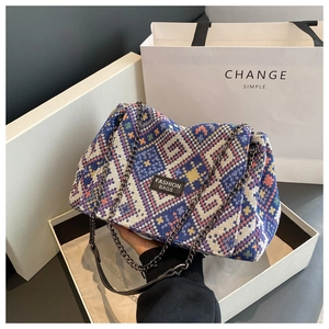 Detail shot of vintage blue jacquard tote bag featuring geometric patterns and metal chain