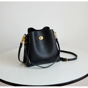 Close-up of black litchi pattern leather bucket bag with elegant golden twist lock hardware