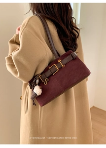 Detail of burgundy suede baguette bag with vintage buckle and plush ice cream charm