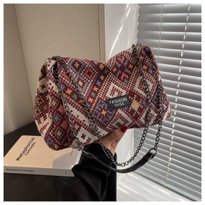 Detail of bohemian woven shoulder bag with geometric patterns and metal chain strap