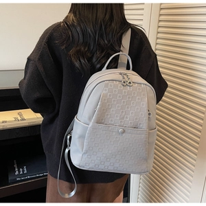 Detail of grey pebbled leather backpack with textured checkerboard pattern pocket for women