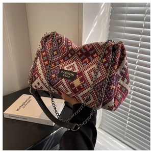 Detail of geometric jacquard woven handbag with metal chain strap and leather handle