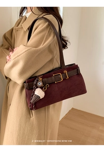 Close-up of retro burgundy suede baguette bag with brown leather strap and ice cream charm