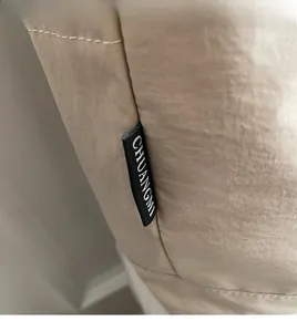 Gros plan sur l'étiquette tissée latérale d'un sac cabas en toile kaki minimaliste
