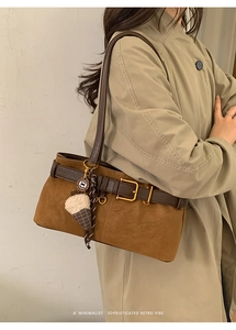 Detail of retro tan shoulder bag with leather buckle and ice cream charm accessory