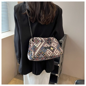 Detailed shot of ethnic woven tote bag with colorful geometric patterns and chain strap