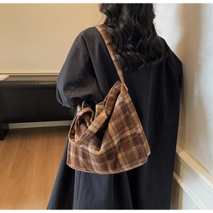 Gros plan d'un grand sac cabas à carreaux montrant la texture et la bandoulière