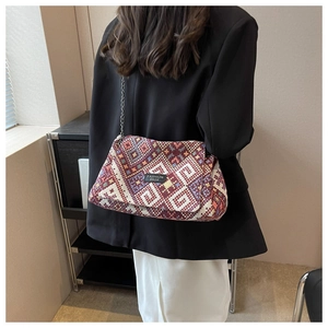 Detail of colorful woven retro tote bag with ethnic patterns and silver chain strap