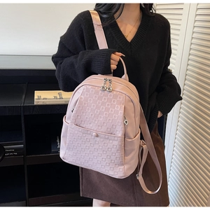 Close-up of pink pebbled leather backpack with unique geometric embossed patterns