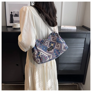 Ethnic geometric woven tote bag with chain strap styled with a white dress