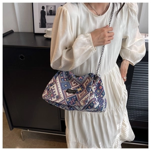 Detail of bohemian geometric woven crossbody bag featuring colorful jacquard and silver chain