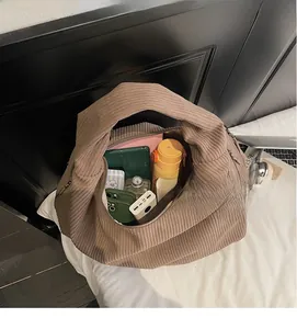 Détail montrant la grande capacité de stockage du sac à bandoulière en velours côtelé